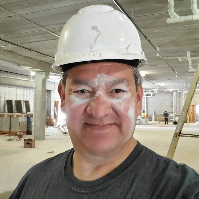 Ruben Contreras, owner of Action Painting & Epoxy Coatings, standing proudly