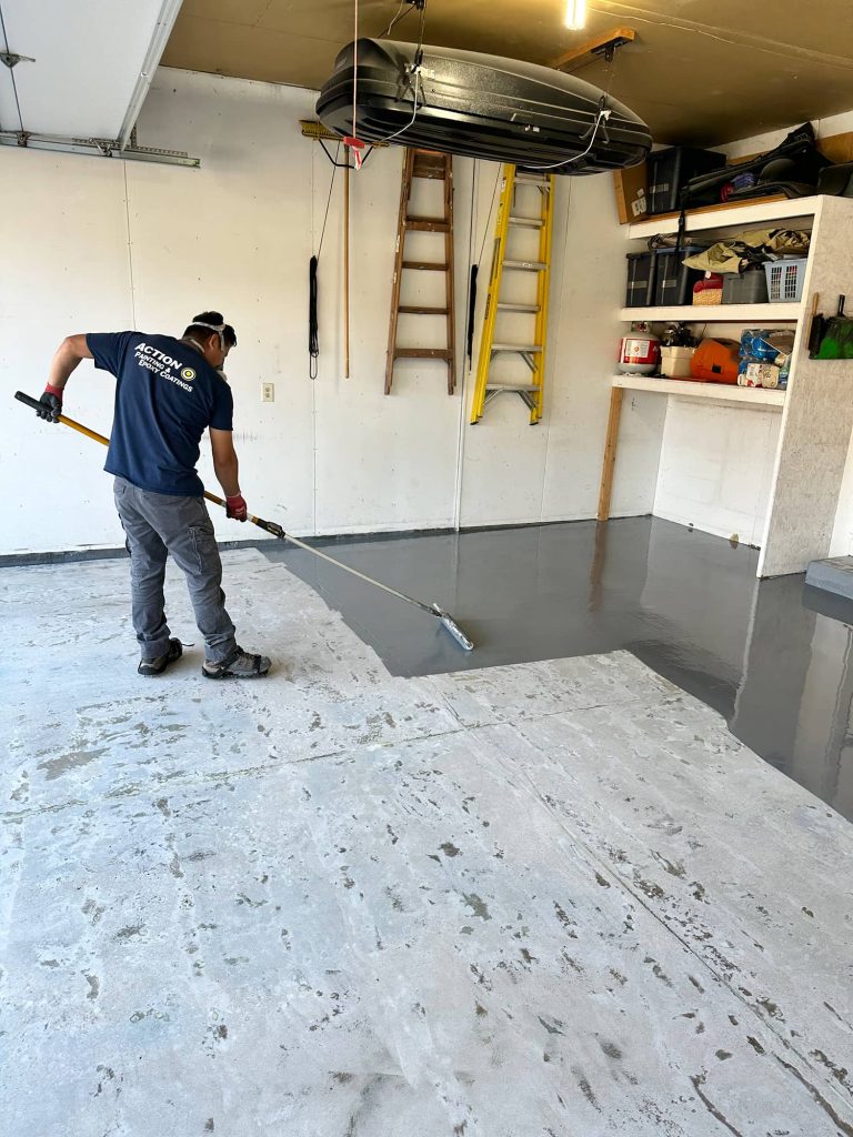 An Action Wis employee applying Expoxy to a garage floor