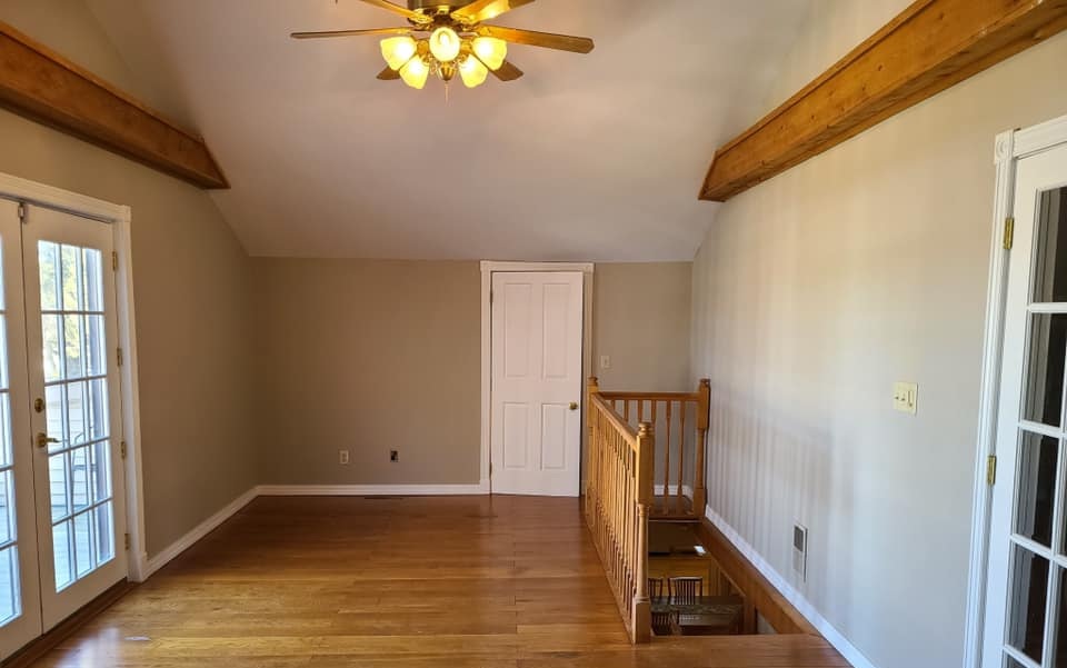 After interior repaint of second-floor loft space with exposed beams and wood flooring in Wisconsin home