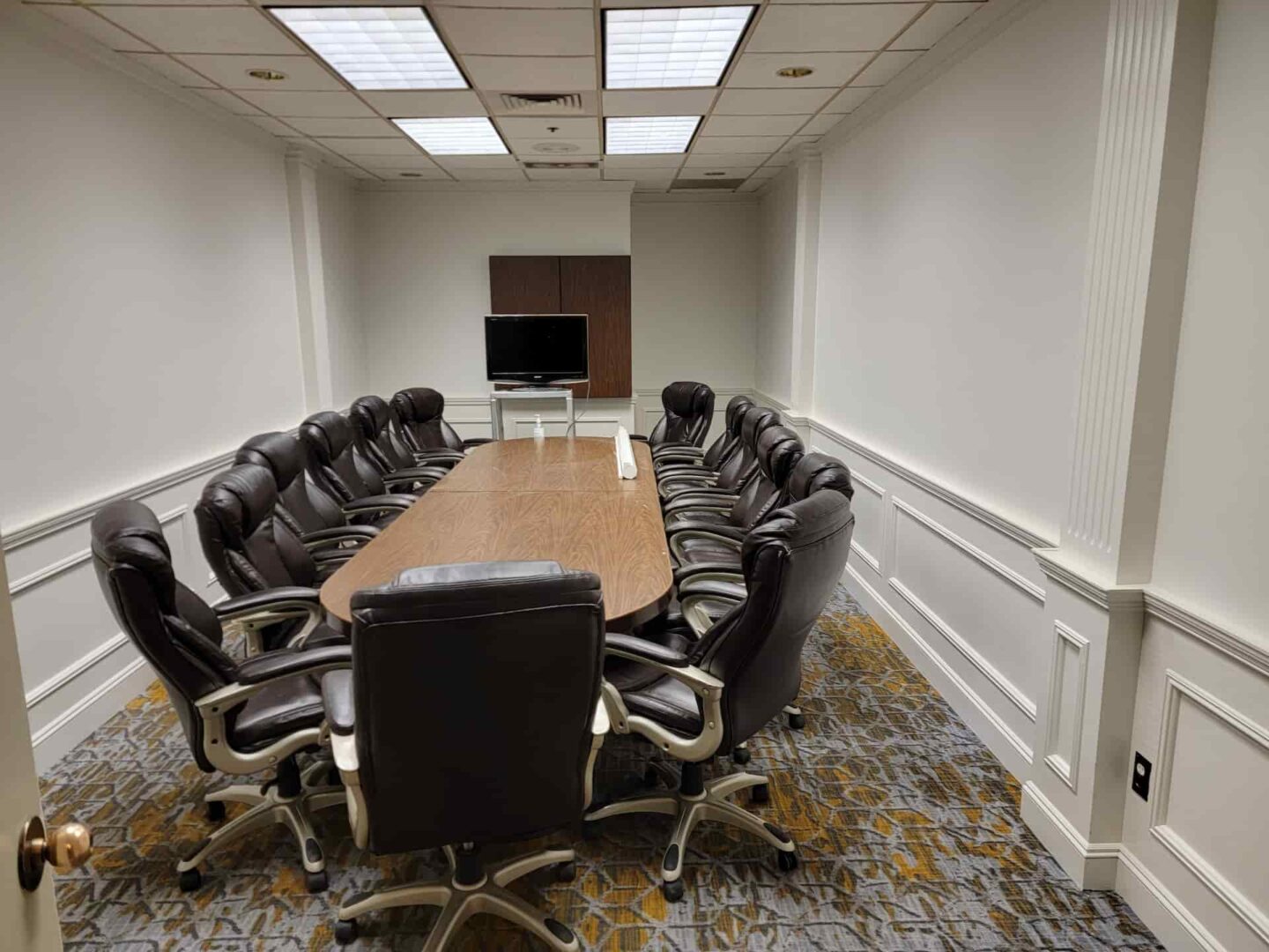 Finished commercial boardroom after professional interior painting with white walls and trim
