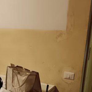 Cigarette smoke stains and yellow tar discoloration on an interior wall, with a clean white painted test patch for comparison.